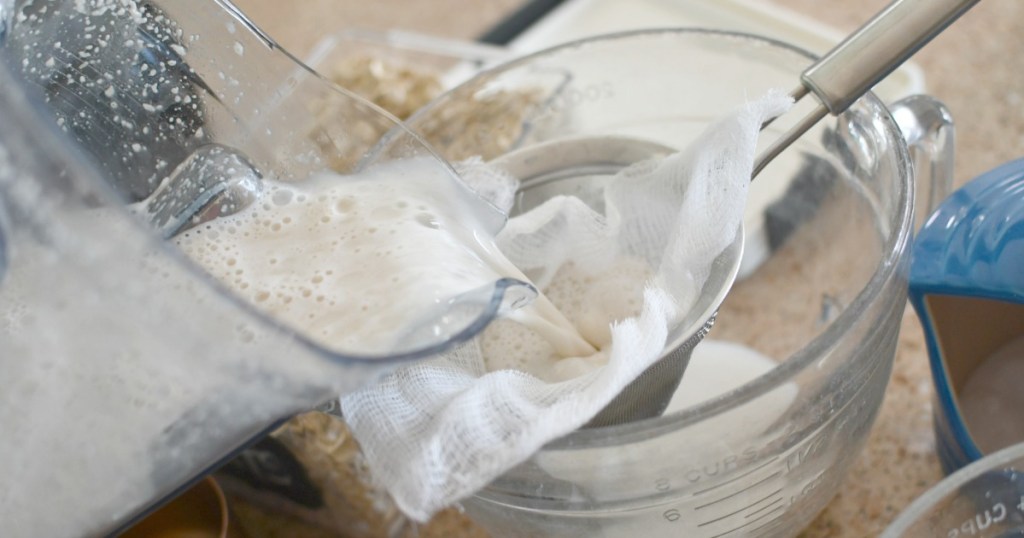 straining oat milk with a cheesecloth