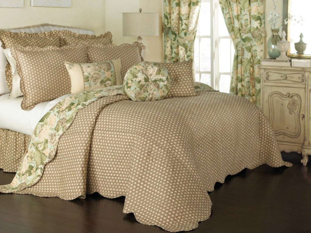 floral and tan with white polka dotted bedspread on bed in bedroom