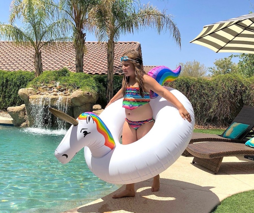girl wearing unicorn pool float around waste 