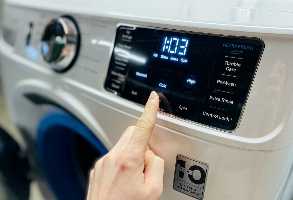 finger pointing to water temperature on washing machine