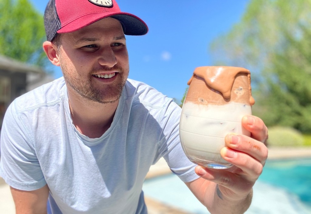 man holding a glass of half milk and whipped nutella