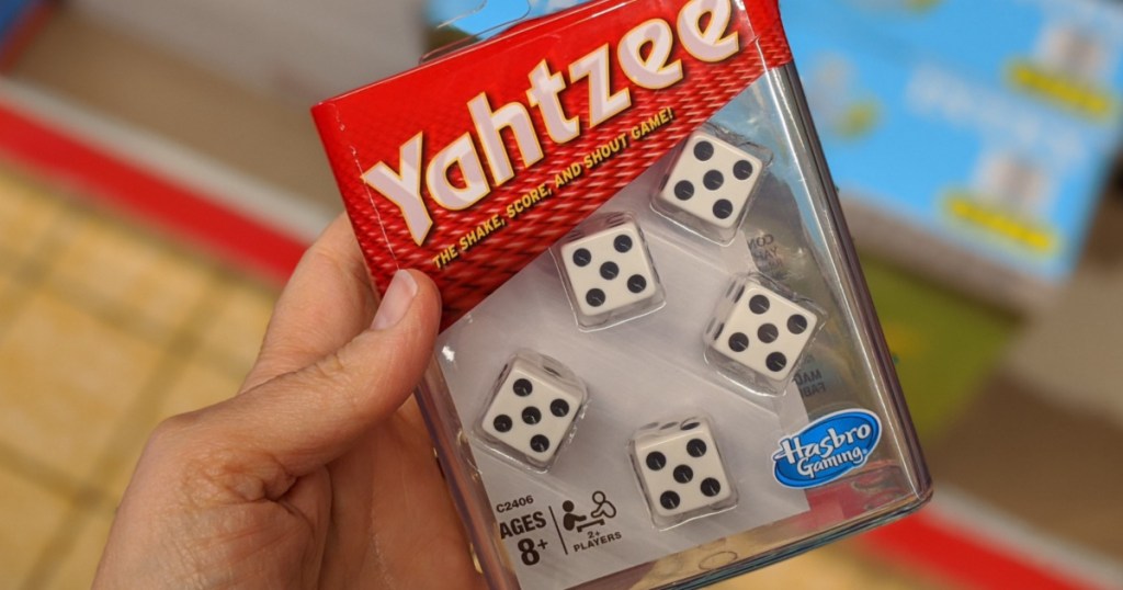 womans hand holding travel yahtzee game