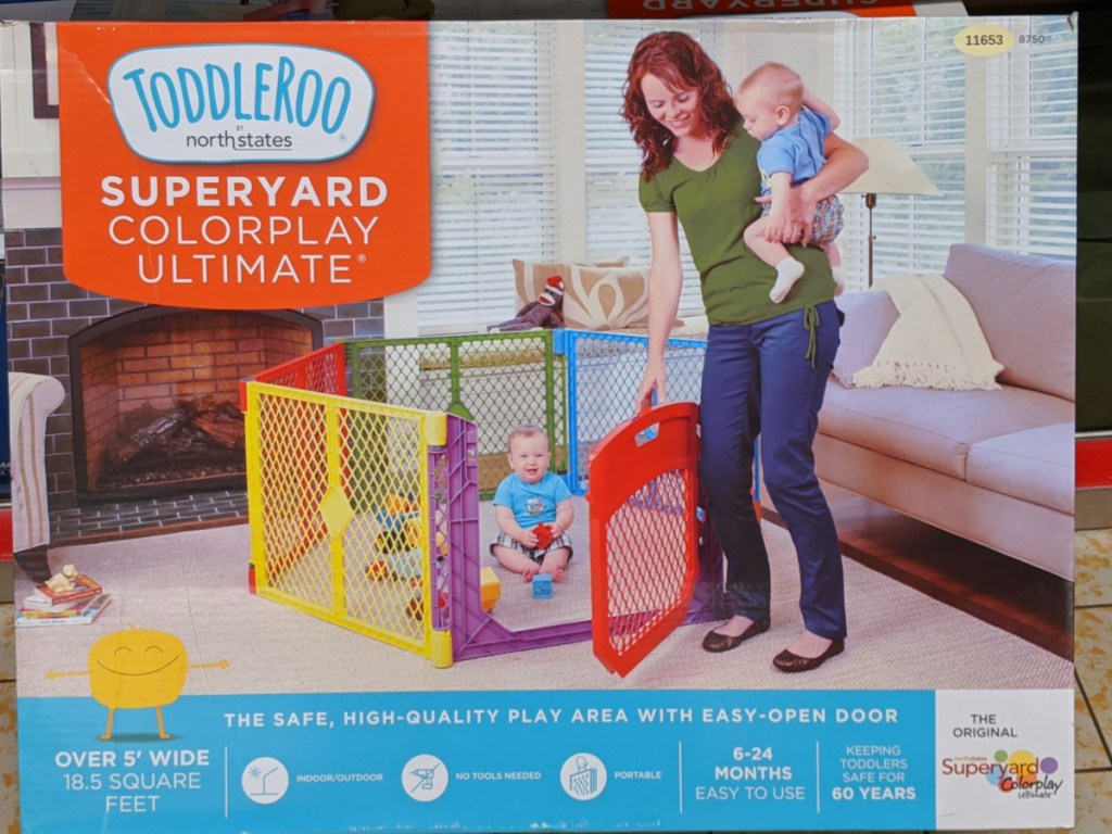 colorful play yard box with woman holding a baby 