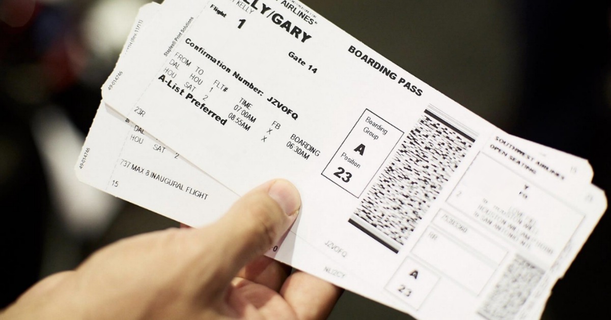 man holding one-way airline tickets for the best times to buy plane tickets and that's one way how to get cheap last minute flights 