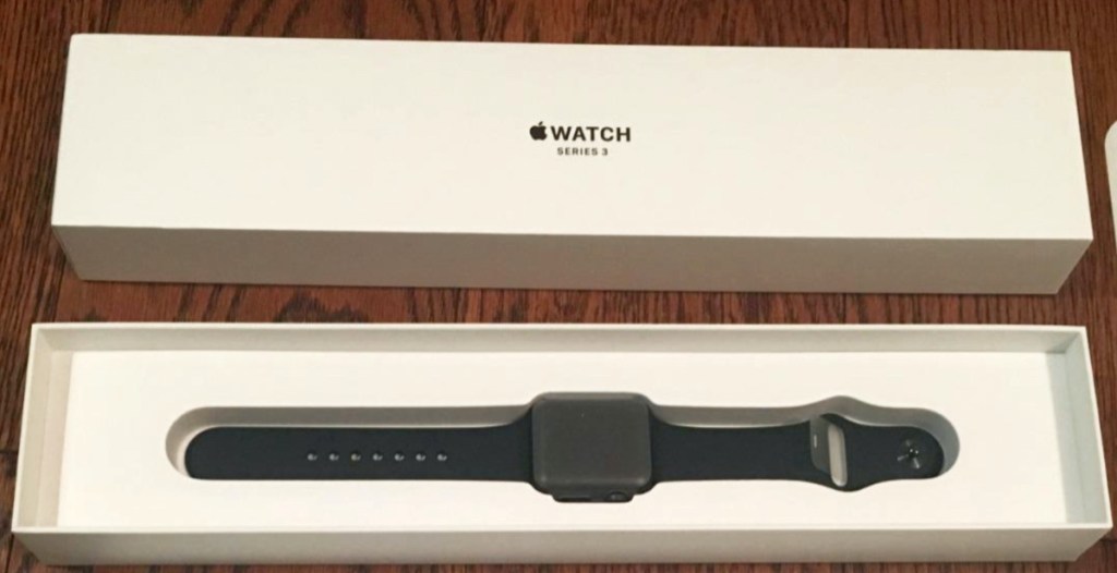 black and gray smart watch in box on wood surface