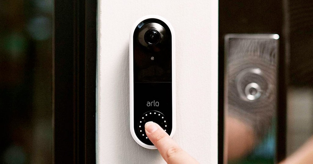 person using finger to ring black arlo video doorbell at front door