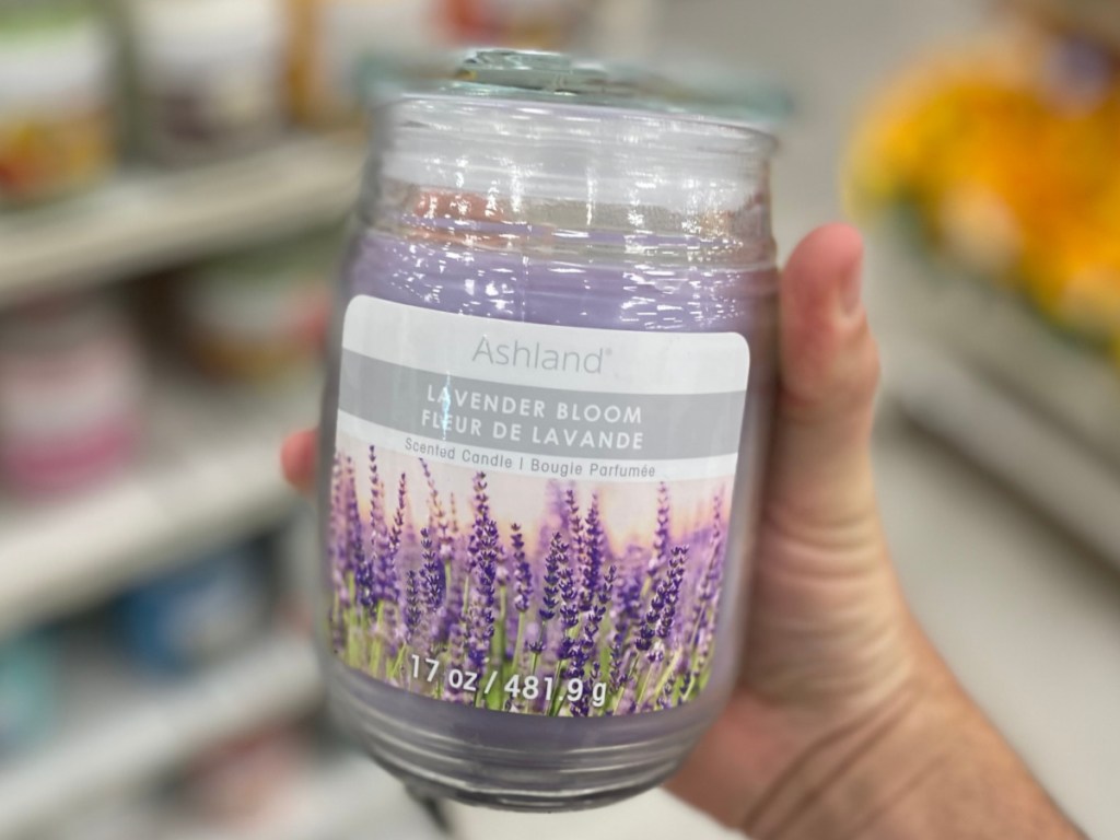 hand holding lavender-scented candle in store