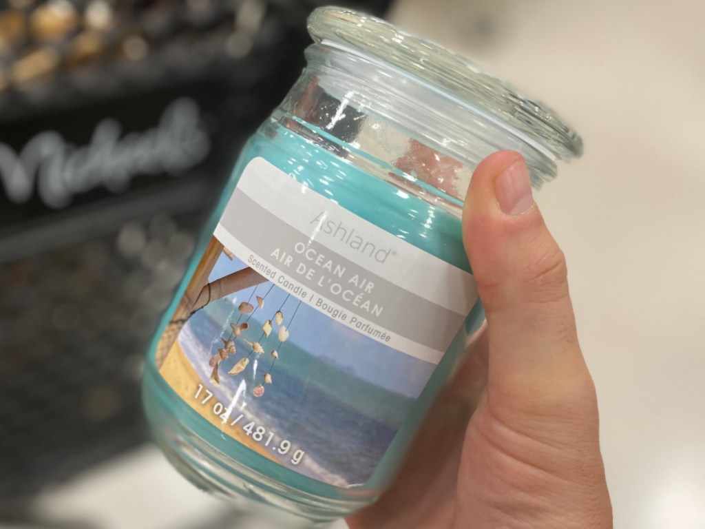 hand holding ocean air scent candle in store