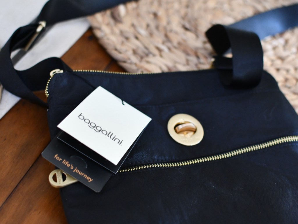 black Baggallini Hanover crossbody Bag laying on a table with tags attached