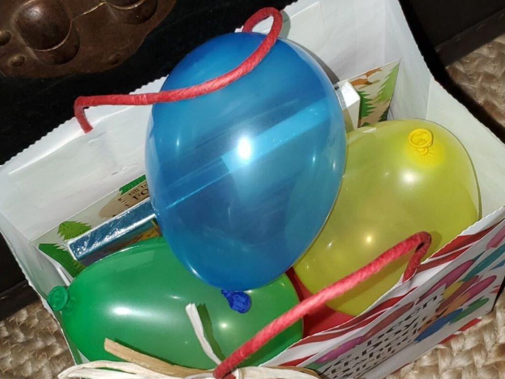 bag with gifts and balloons inside
