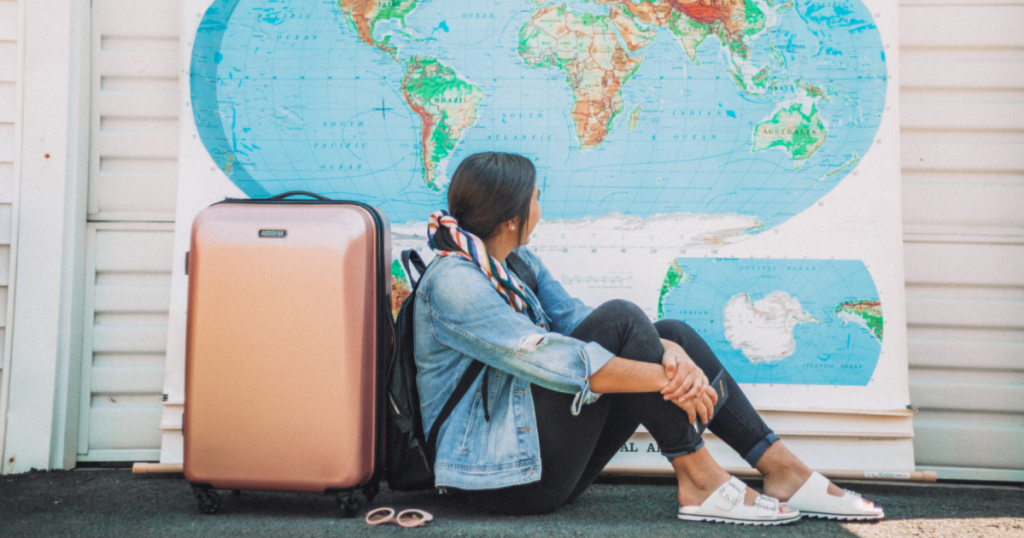 american tourister luggage rose gold behind woman looking at map