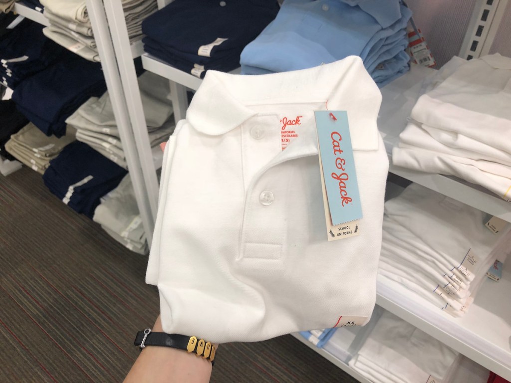 hand holding white cat and jack polo shirt in store