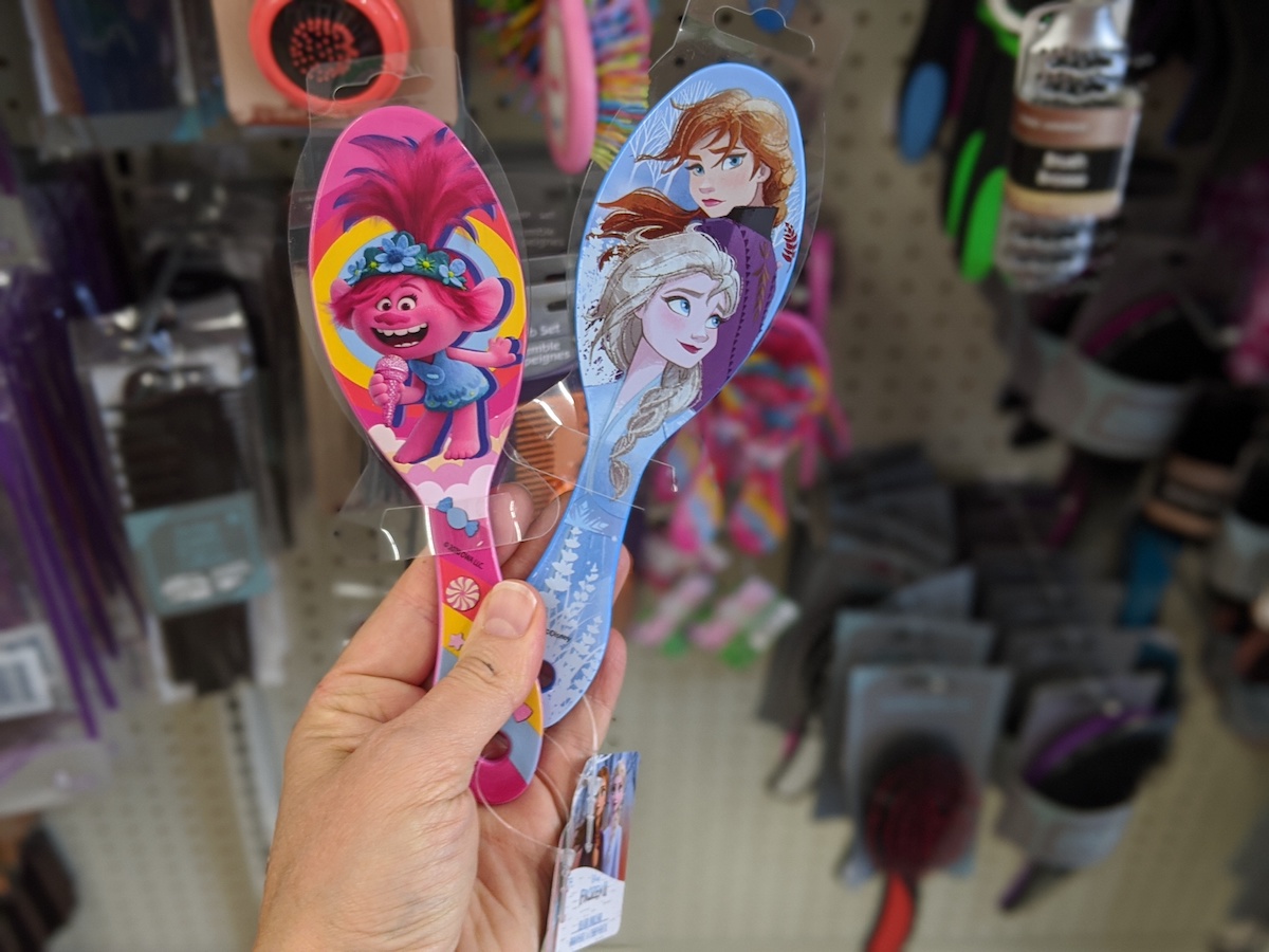 hand holding two Character Hairbrushes