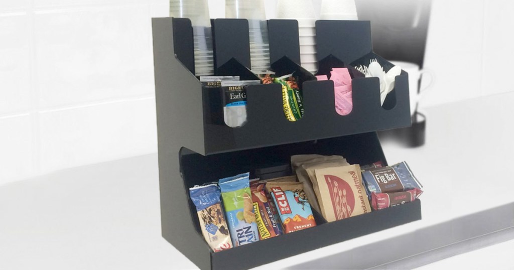 black coffee organizer on counter filled with cups, tea bags, sugar packs, and snacks