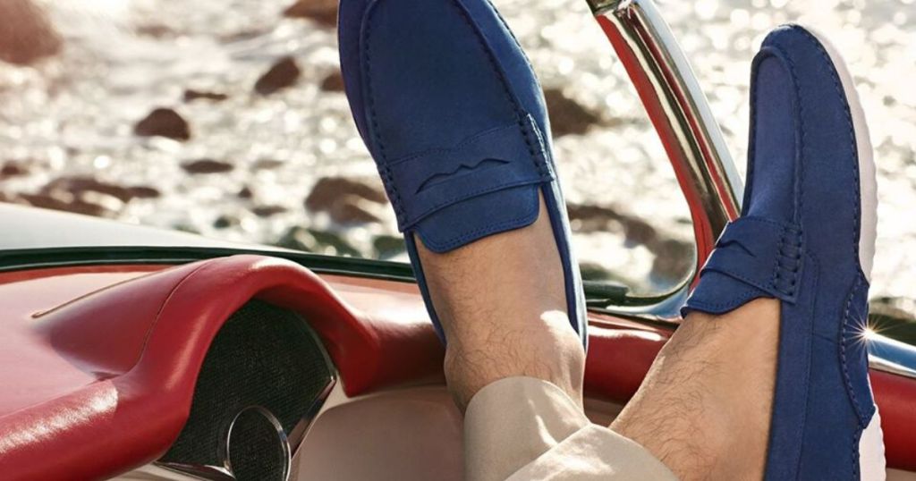 man wearing penny loafers with feet up on car dash