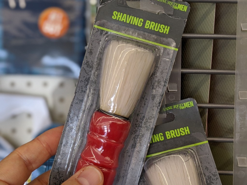 hand holding men's shaving brush in-store at dollar tree