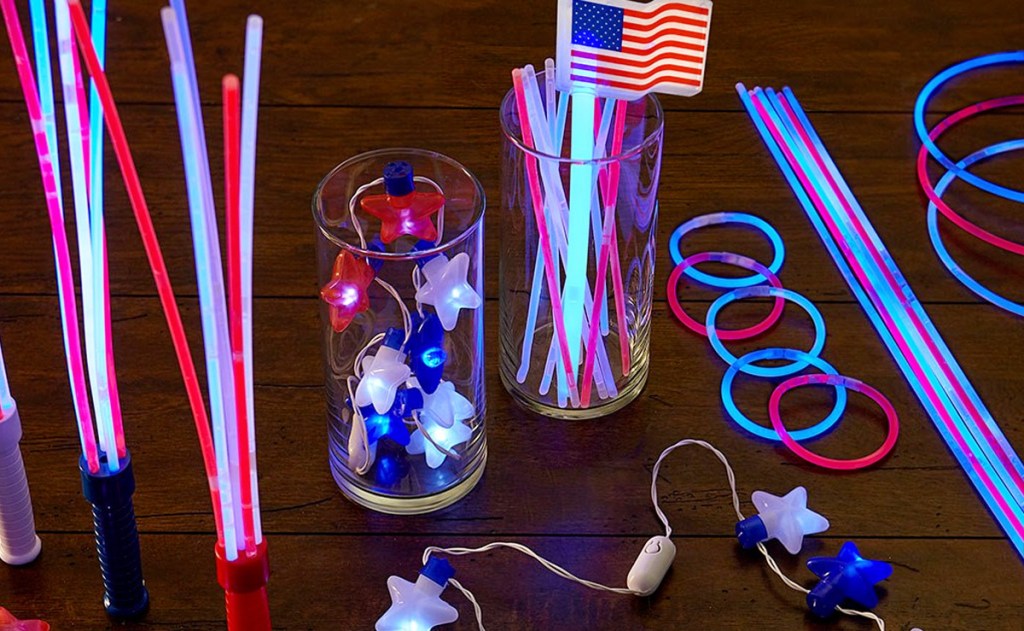 red, white, and blue colored glow sticks and star shaped lights on table in dark