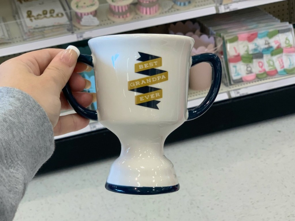 hand holding Father's Day themed mug by store display
