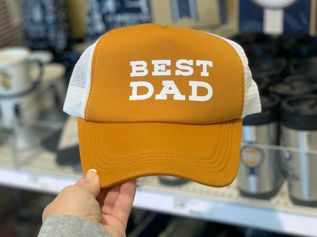 hand holding man's ball cap by store display