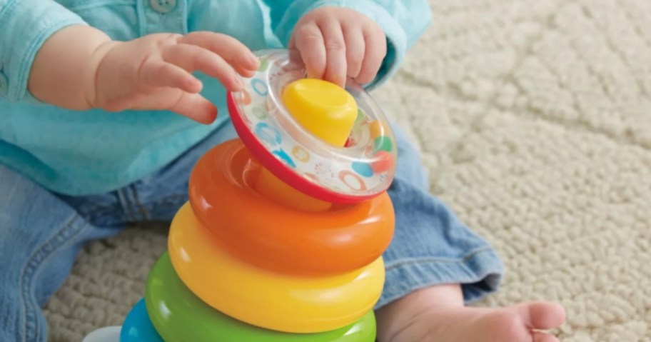 baby playing with Fisher-Price Rock-a-Stack Sleeve Infant Stacking Toy