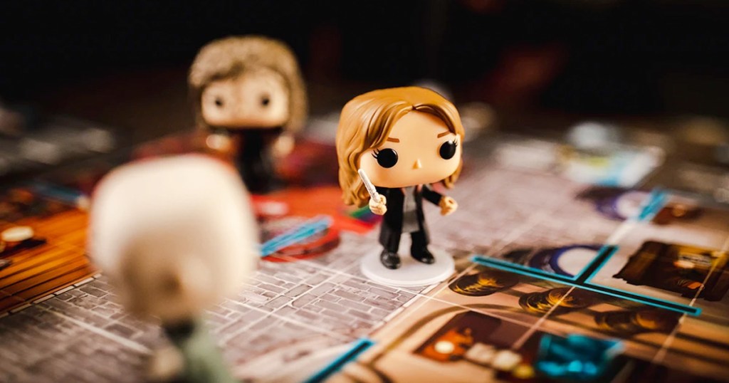 mini funko pop harry potter characters on top of a board game