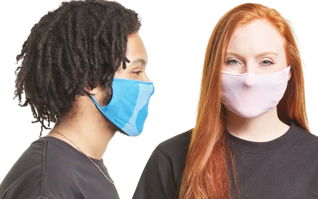 side view of a man wearing blue face mask and woman wearing light pink face mask