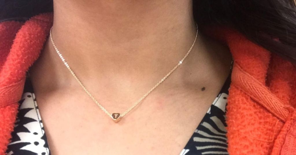 woman wearing small heart necklace