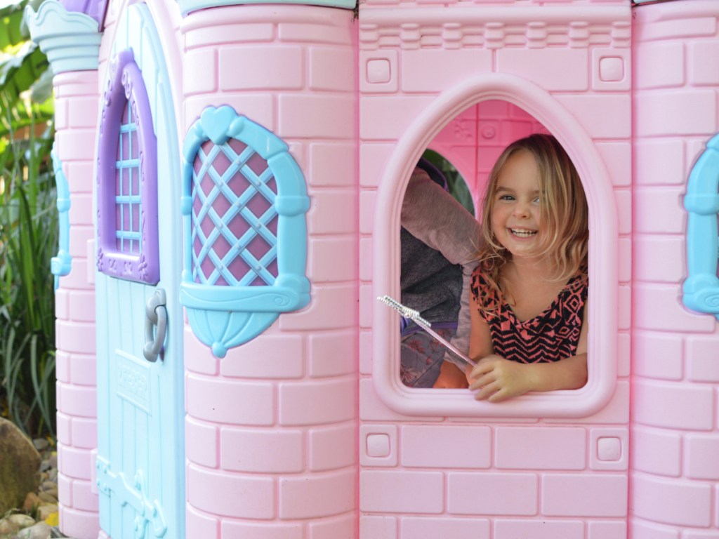 pink blue and purple castle with little girl poking head out