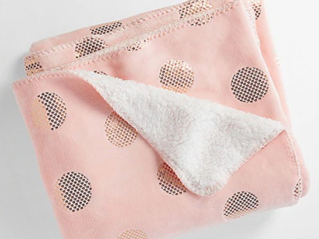 pink and gold polka dot blanket folded with a corner folded back 