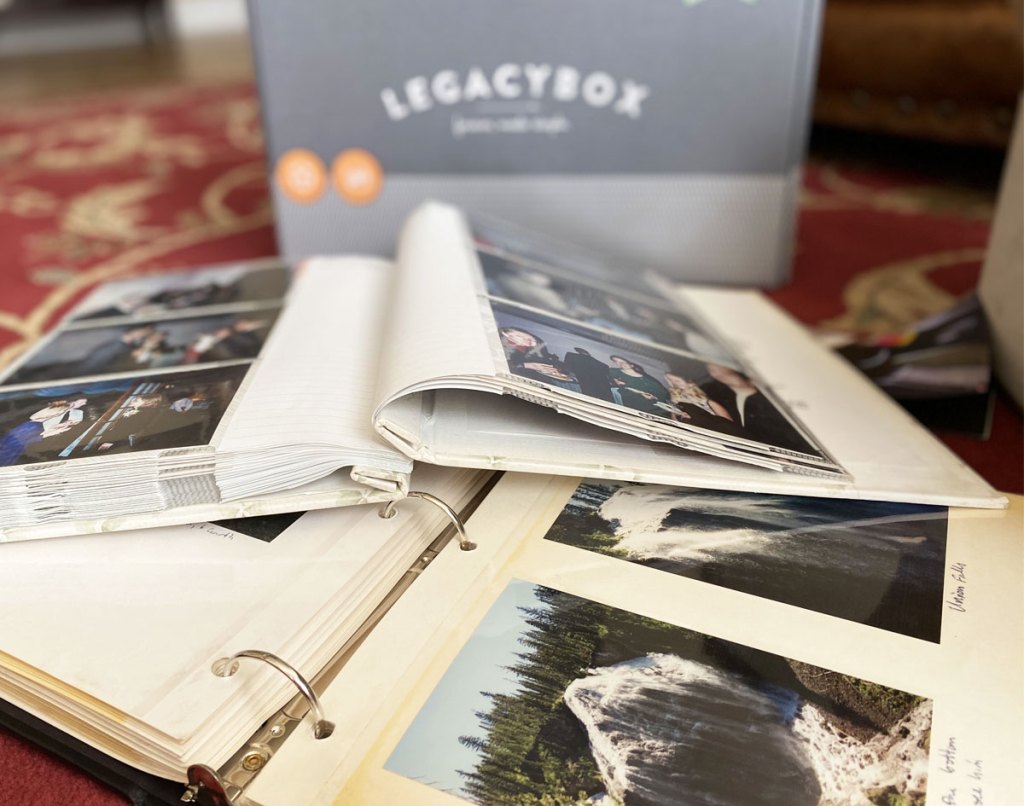two open photo albums on floor in front of legacybox starter kit box