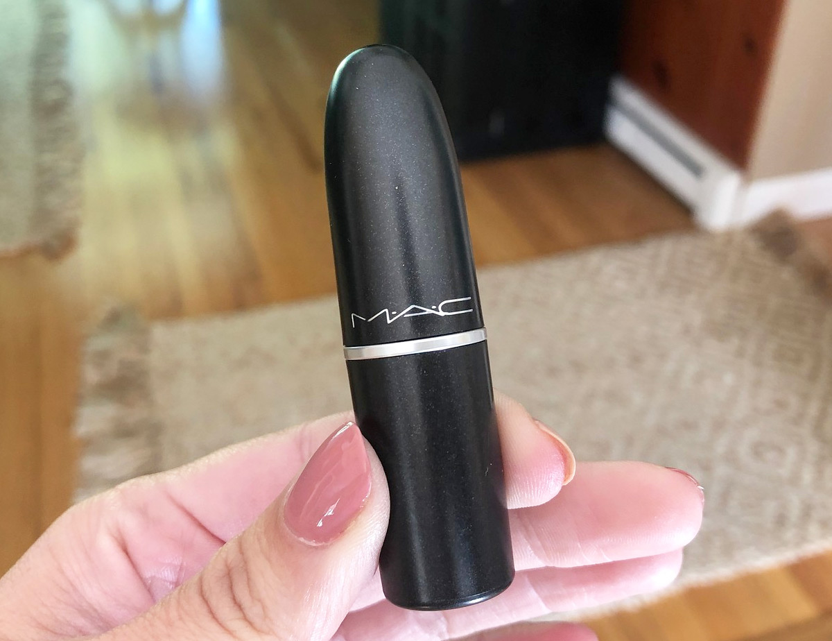person holding up a black tube of mac lipstick
