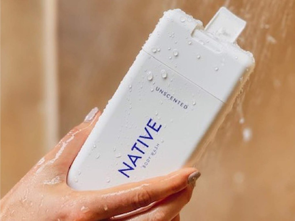 hand holding native body wash in a shower