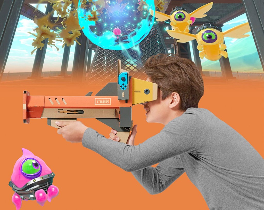 boy in grey long-sleeve shirt playing with VR goggle and blaster in video game