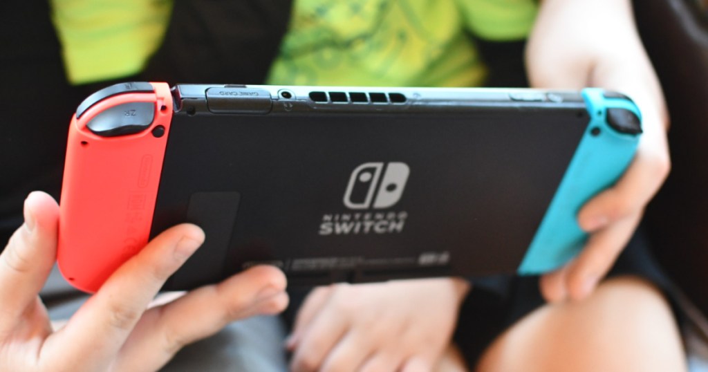 child holding gaming console in car