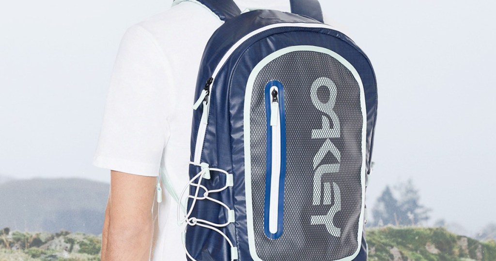 man in white shirt with blue oakley backpack on his back