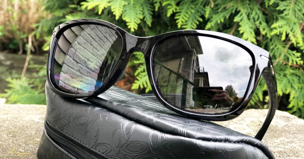 pair of black oakley sunglasses sitting on case outside