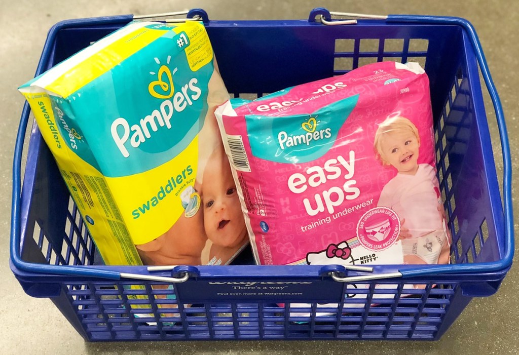 yellow and teal colored package of pampers diapers and pink package of easy-ups in blue shopping basket
