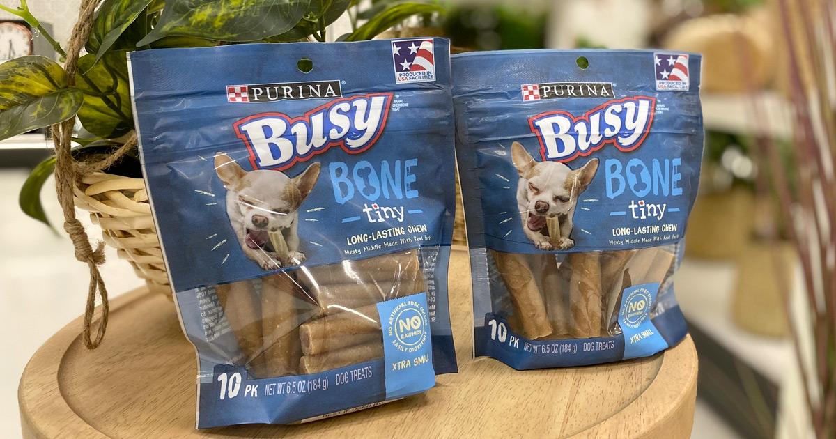 two blue bags of purina busy bone dog treats on wooden table
