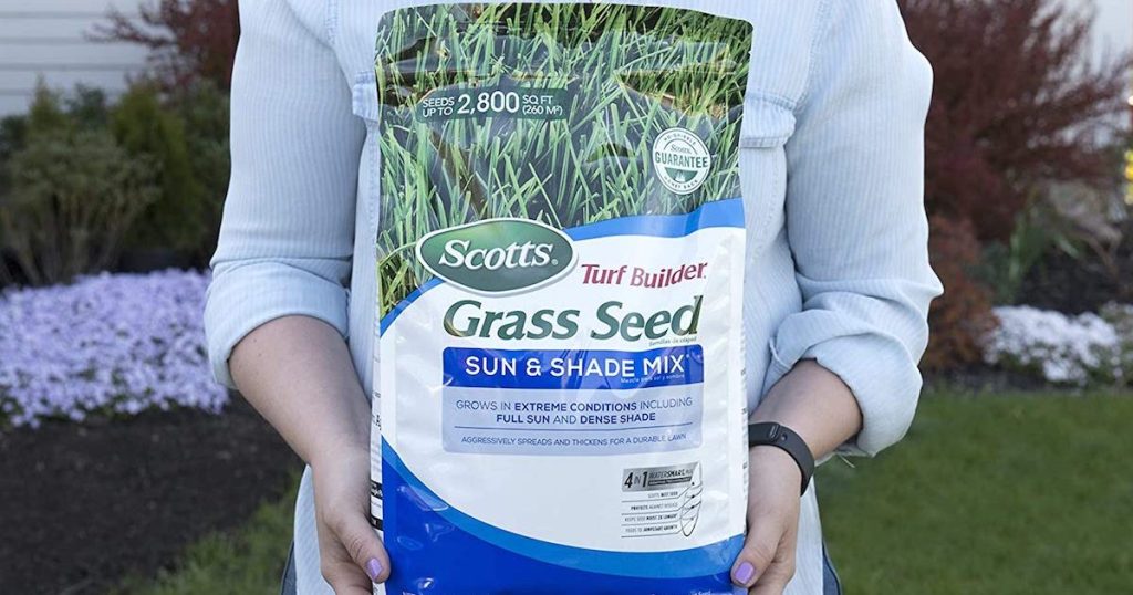 woman holding Scotts grass seed bag