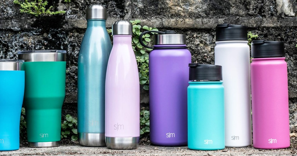 various shapes and colors of stainless steel water bottles sitting on stone wall