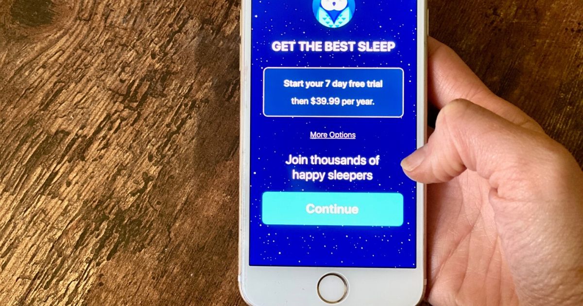 Hand holding a phone with the Slumber app premium subscription displayed
