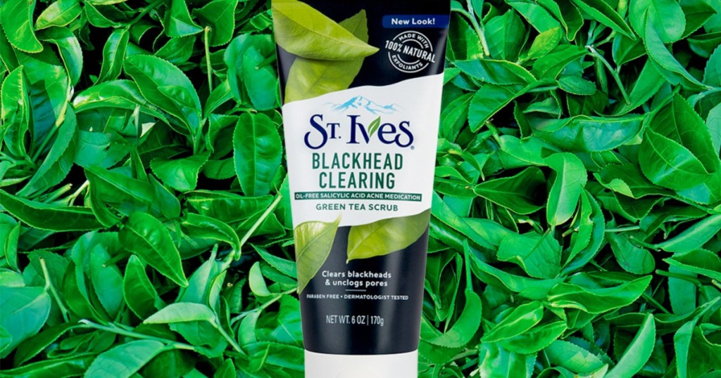 black and green bottles of st ives blackhead clearing facial scrub with green tea leaves in background