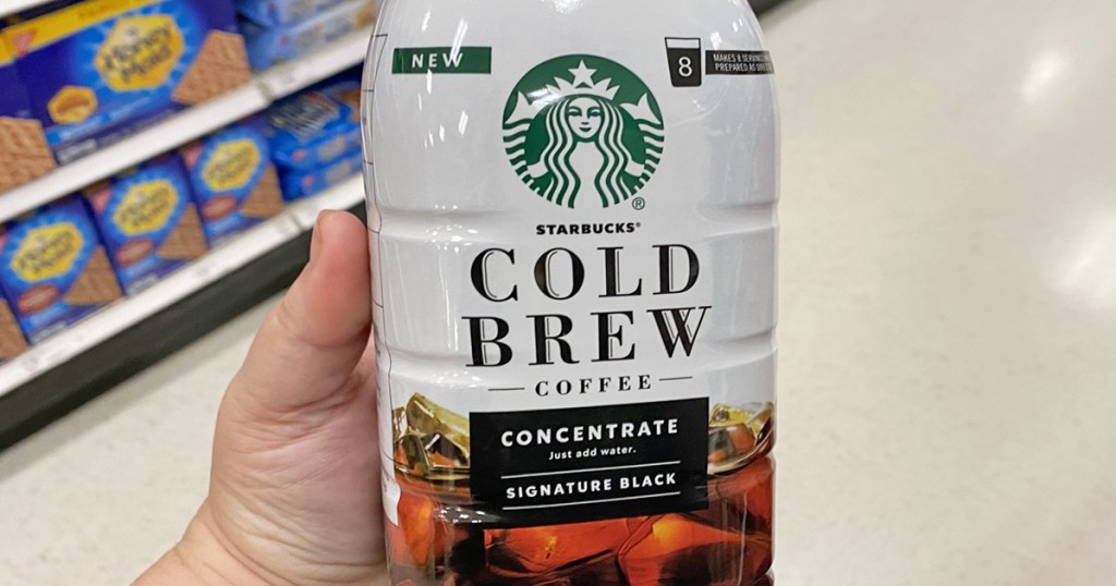 person holding a white bottle of starbucks cold brew concentrate in their hand