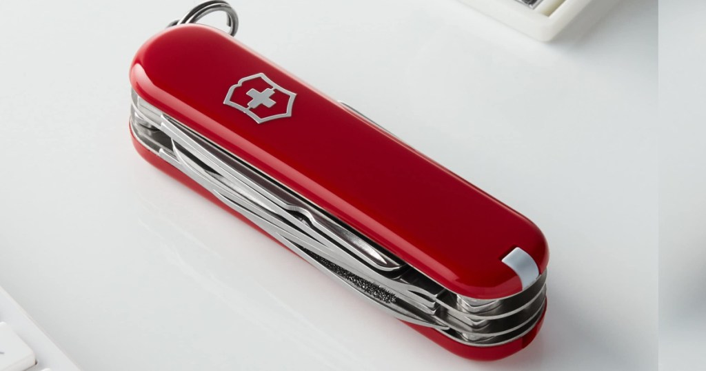 swiss army pocket knife closed and laying on a desktop 