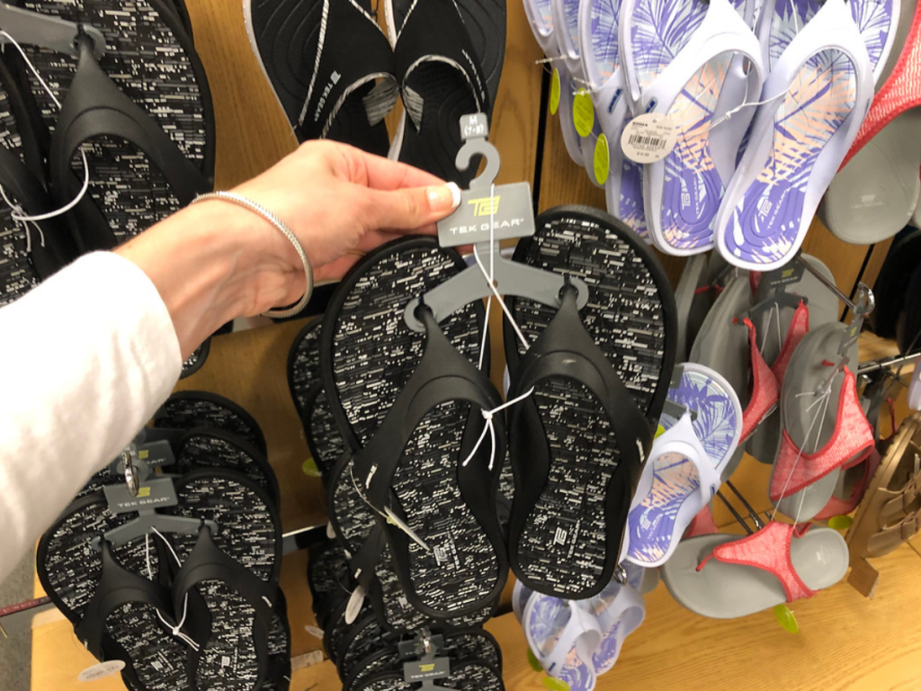 women holding up sandals in store