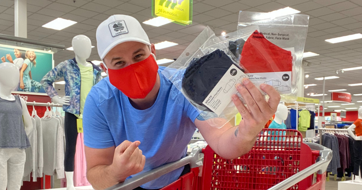 man holding black and red face masks at target by cart