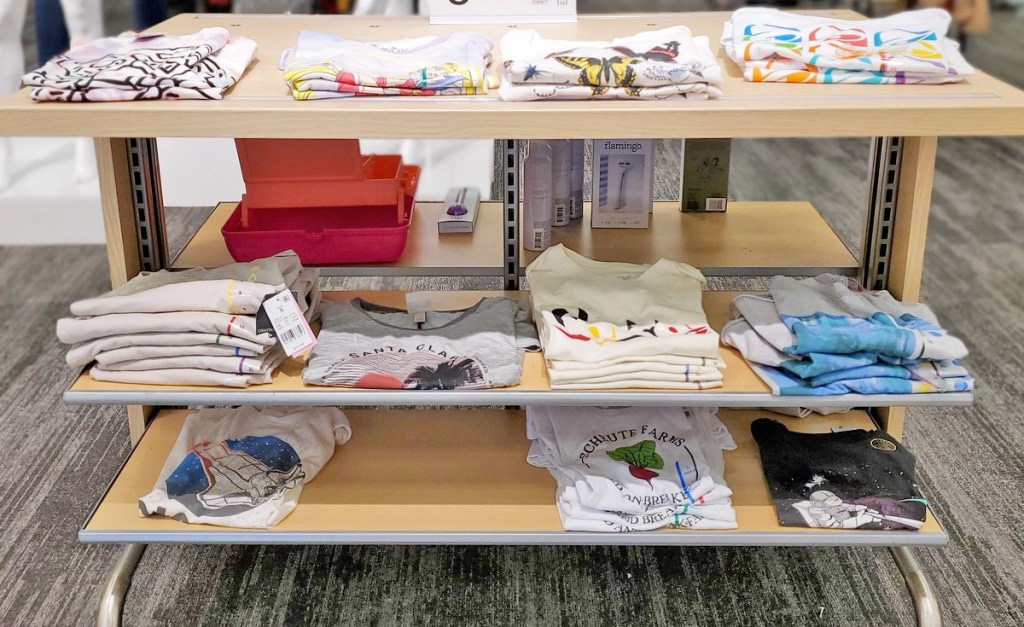 store display shelves of various women's graphic tees