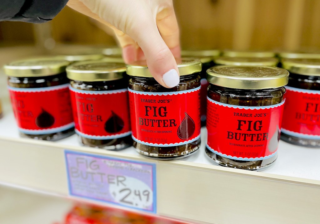 hand pulling red jar of fig butter off shelf - best Trader Joe's items
