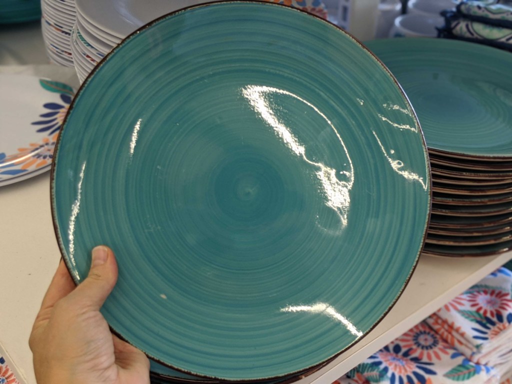 hand holding turquoise plate in store