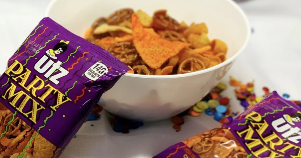 bowl of party mix and two bags of party mix on either side